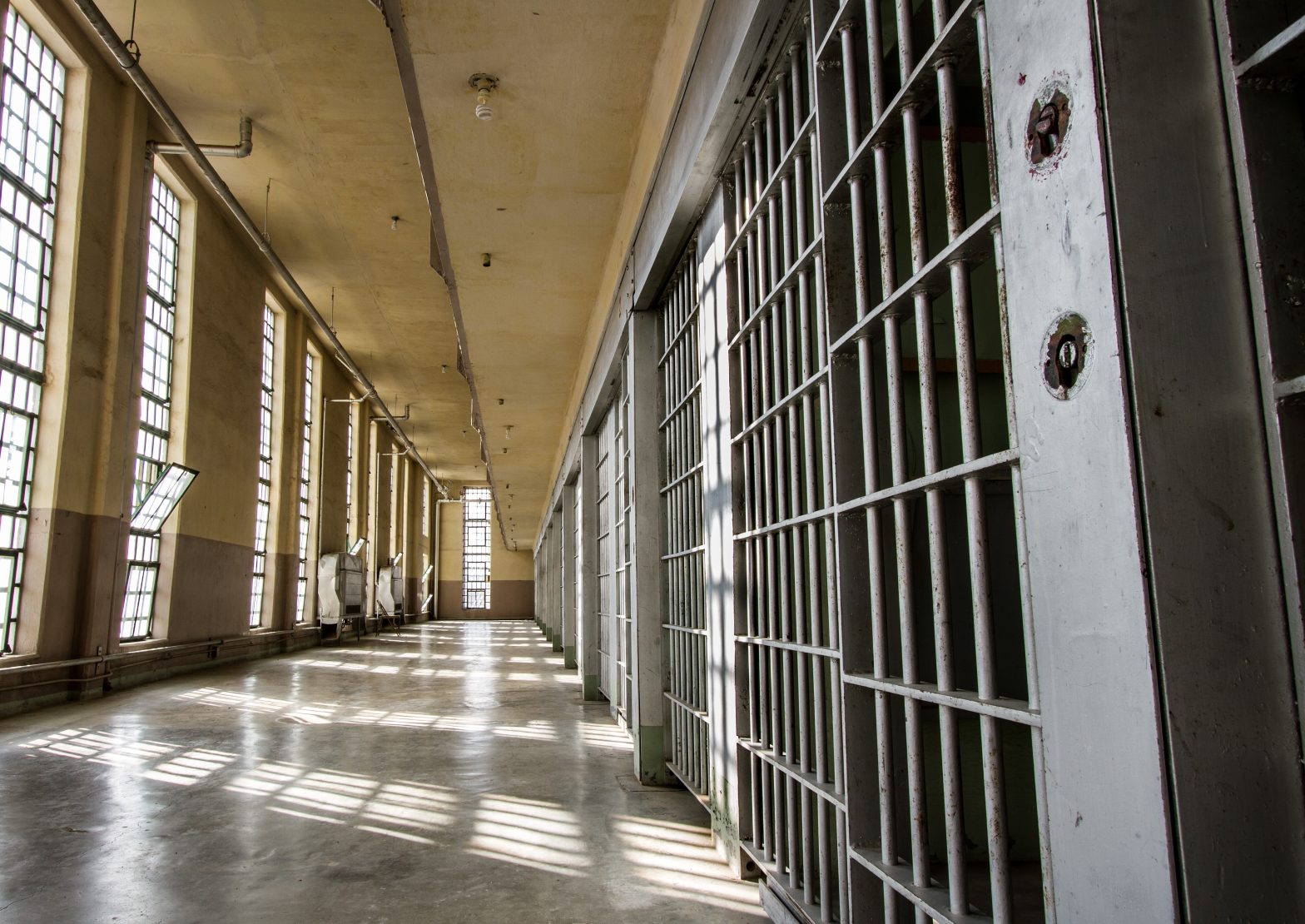 View inside a prison, featuring cell bars and a corridor in a correctional facility. prison drug smuggling - Jason Tran