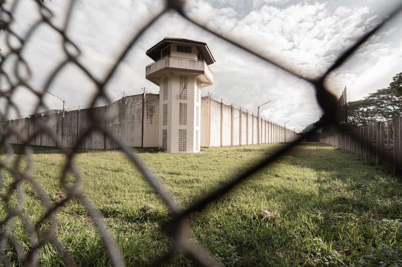 Exterior view of a prison facility surrounded by imposing iron fences.