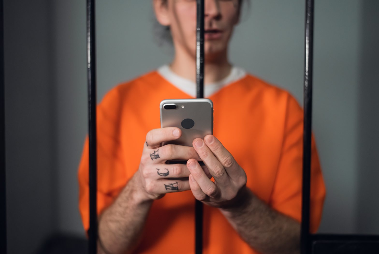 A prisoner behind bars, mobile phone in hand. Andy Steven Johnson - United States Penitentiary Atlanta