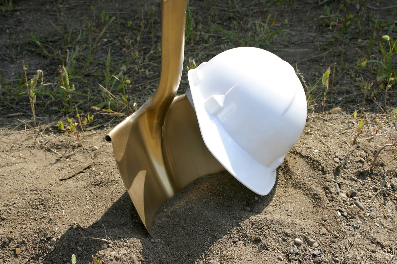 A hard hat and golden shovel in a groundbreaking ceremony. Leavenworth Federal Prison