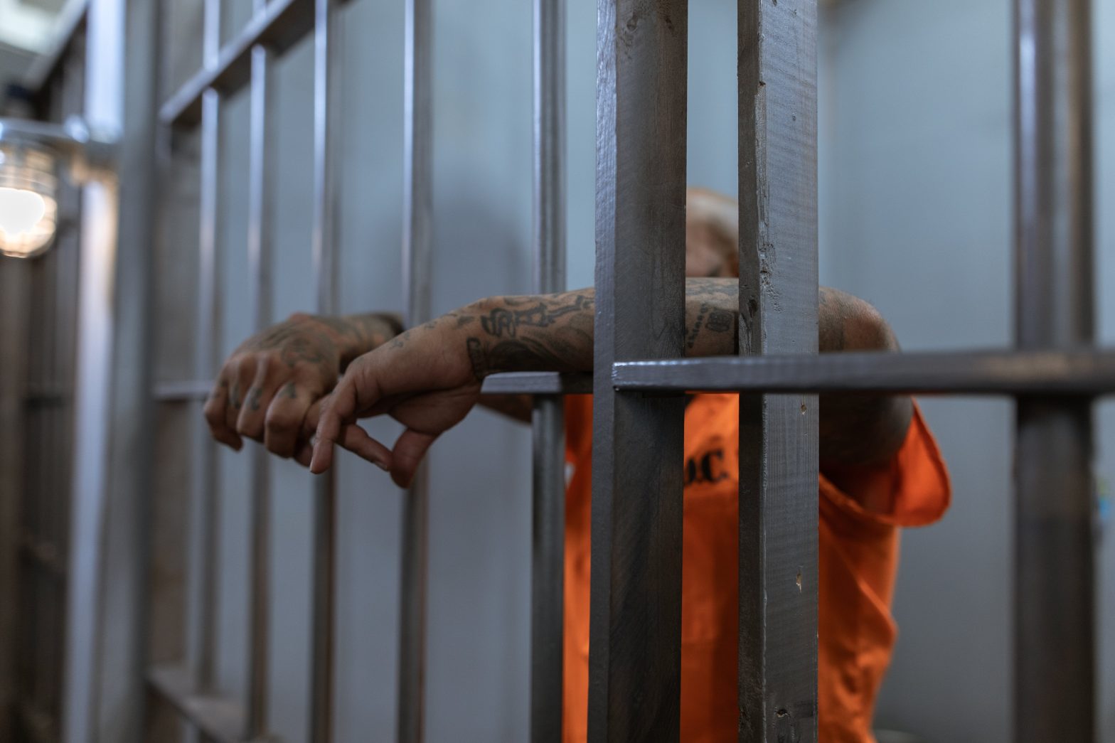 A man in prison garb behind bars. News - Coffee Creek Correctional Facility