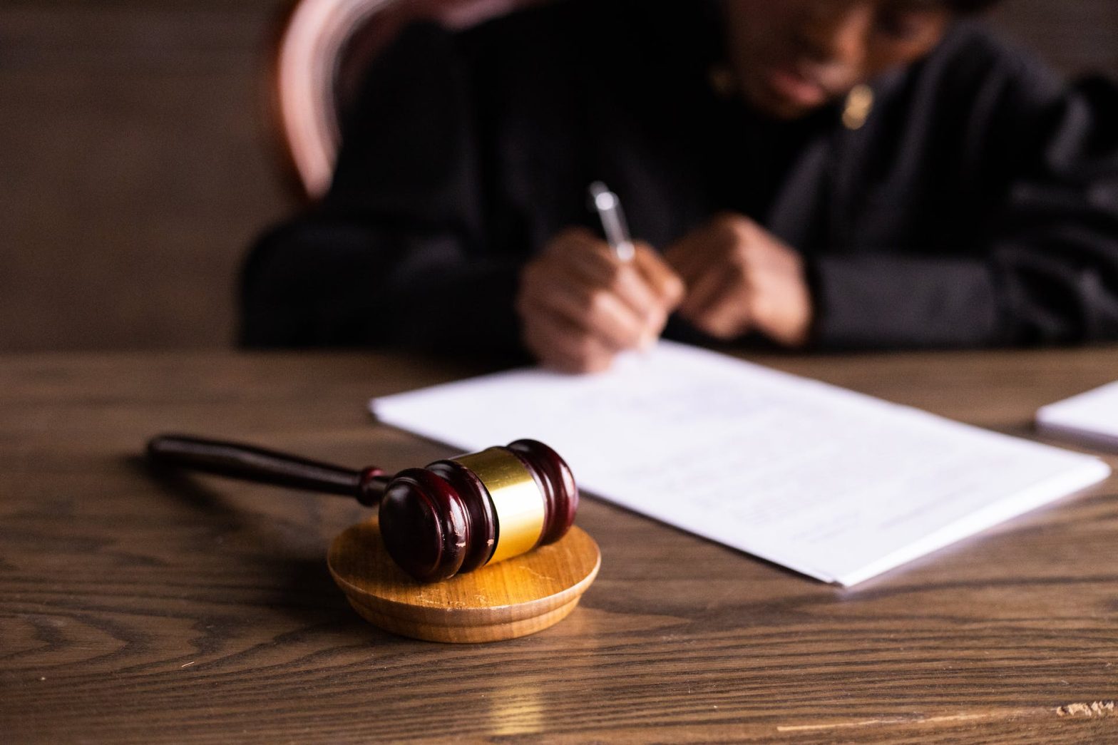 A judge signing court documents. News: John Turscak faces attempted murder charges for Derek Chauvin stabbing