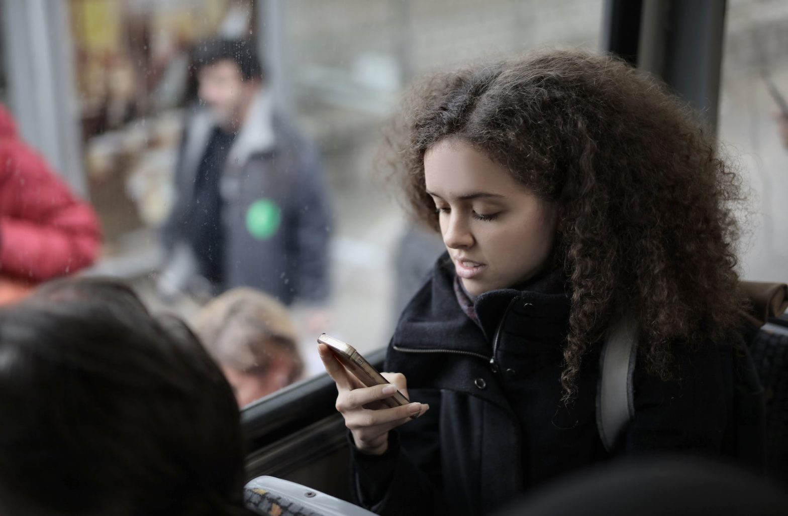 A young woman in a bus using her mobile phone. News - Reunification Ride provides free transportation for families to visit Logan Correctional Center