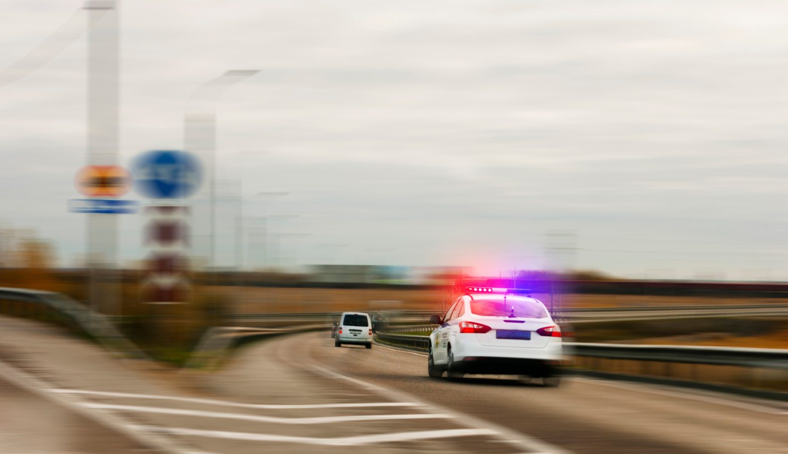 A police car chasing the offender on the road with flashing lights. News - South Carolina prison drug scheme busted; Zachariah Ryan Luke and Evin Rae Davenport sentenced to federal prison