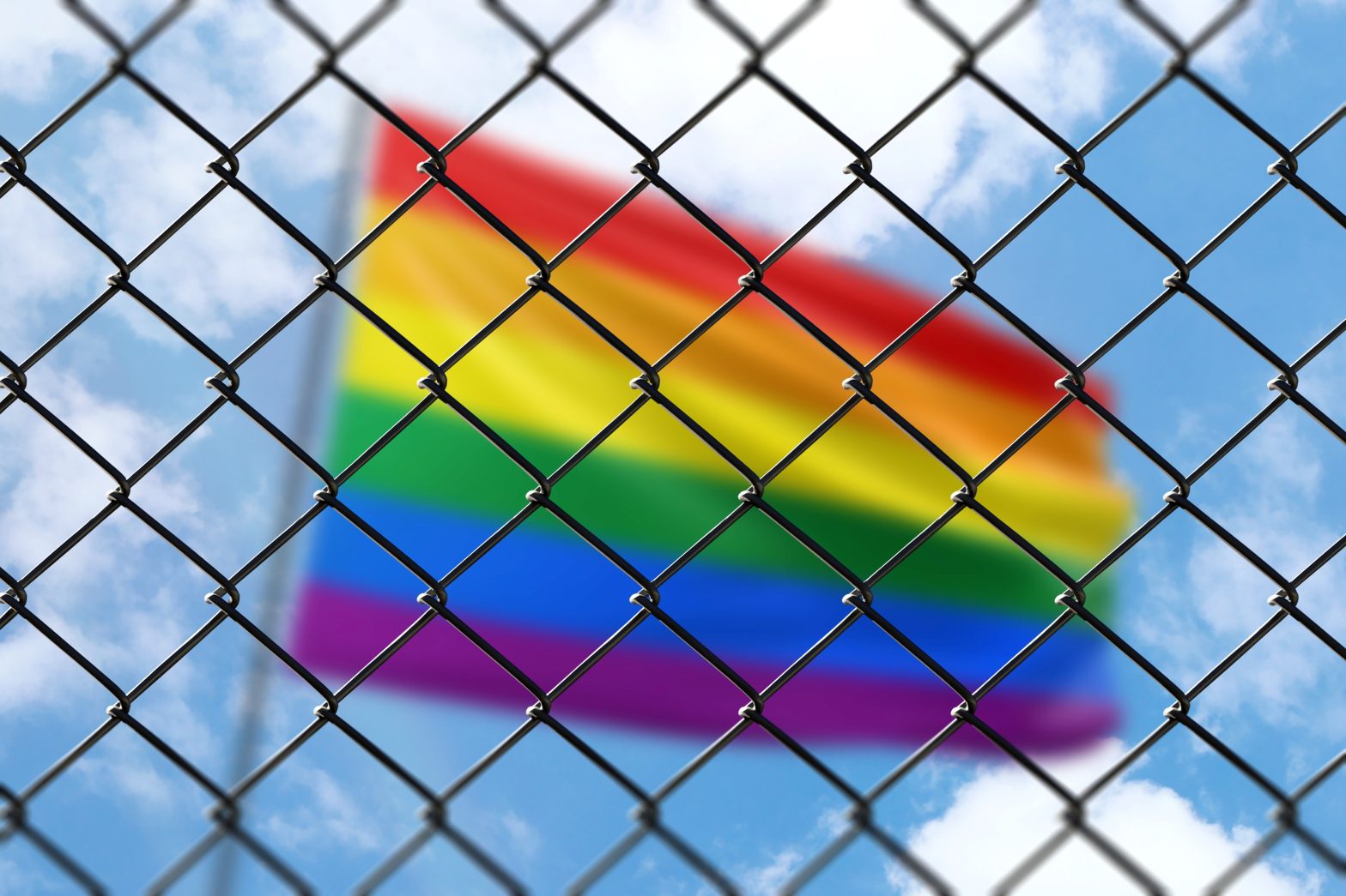 A lgbt pride flag behind a fence. News - Ali Miles seeks justice with $22 million lawsuit against NYC for transgender rights violation