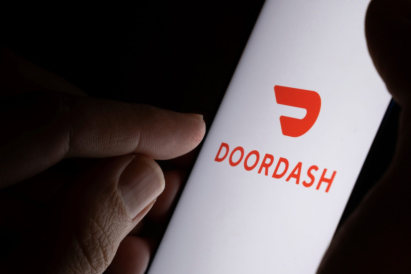 Doordash company logo on a mobile phone screen. News - Jail guard Amara Brown admits to DoorDash delivery for inmate
