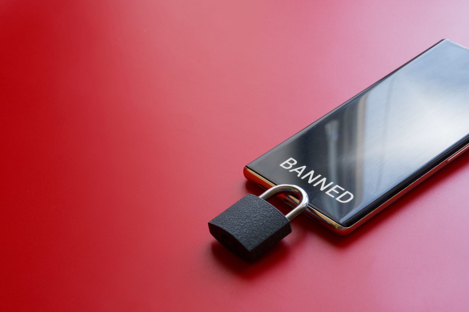 Modern mobile phone is a smartphone with the inscription "banned" and padlock on a red background. News - St. Louis City Justice Center implements phone ban for attorneys
